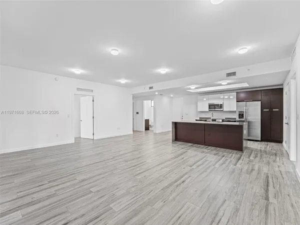 a view of kitchen with kitchen island wooden floor center island and stainless steel appliances