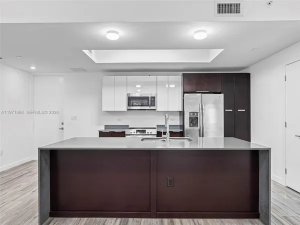 a kitchen with stainless steel appliances granite countertop a sink a stove a refrigerator a microwave and cabinets