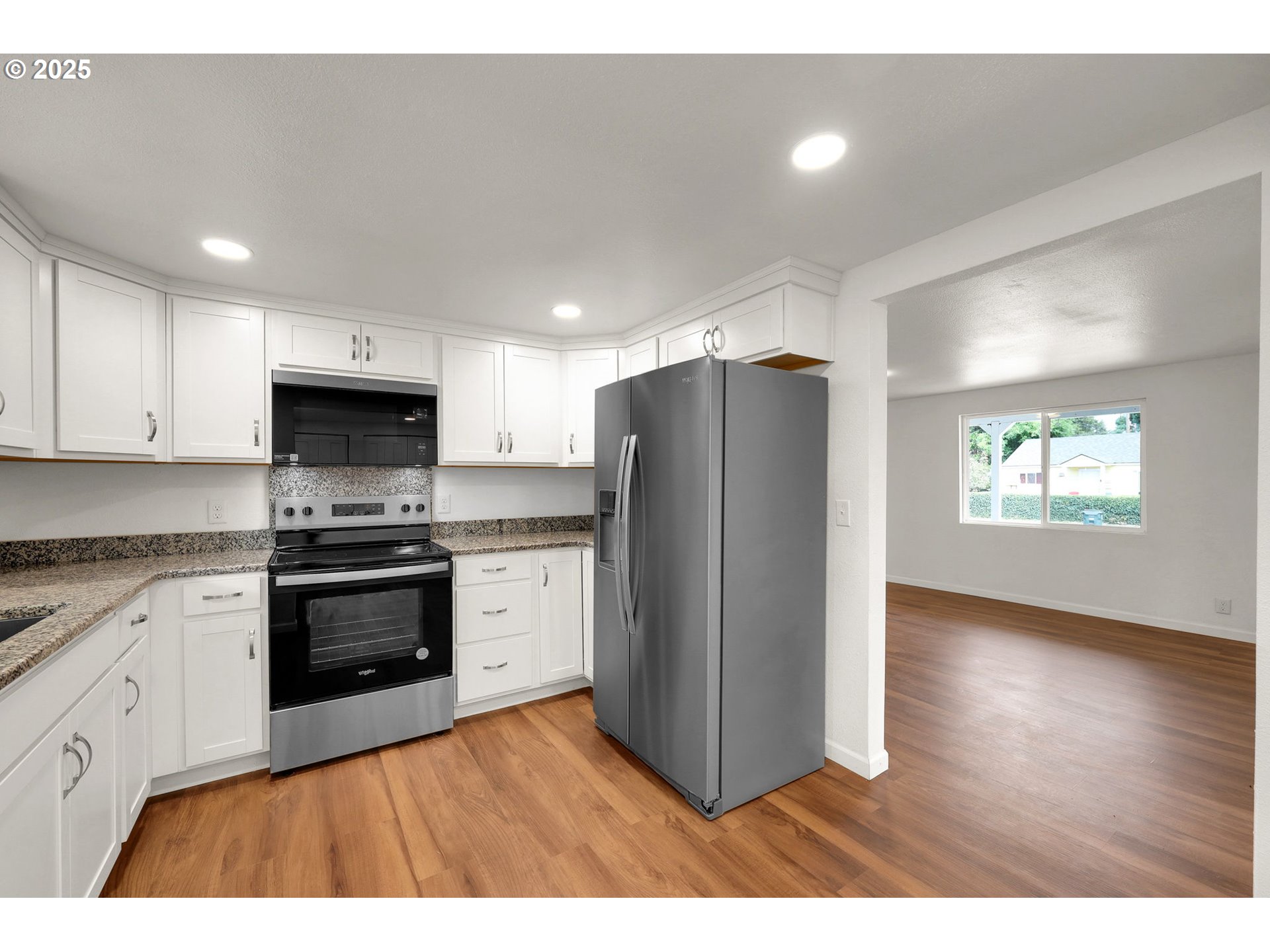 2665 E Street Springfield, OR 97477 - Photo 12 of 37 a kitchen with stainless steel appliances granite countertop a refrigerator a stove top oven a sink and dishwasher with wooden floor
