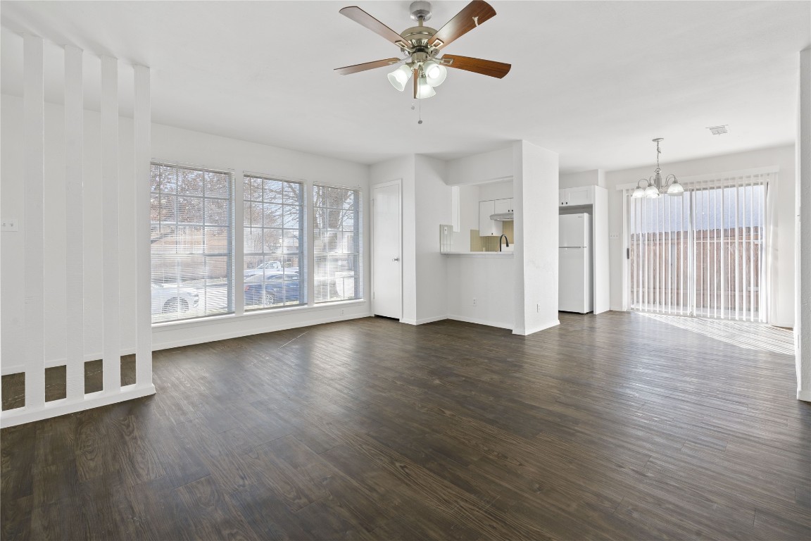 a view of a livingroom with wooden floor and a ceiling fan