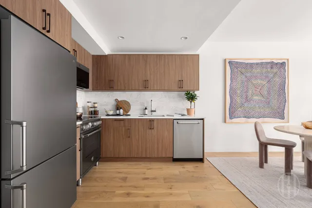 a kitchen with stainless steel appliances a dining table chairs and a refrigerator