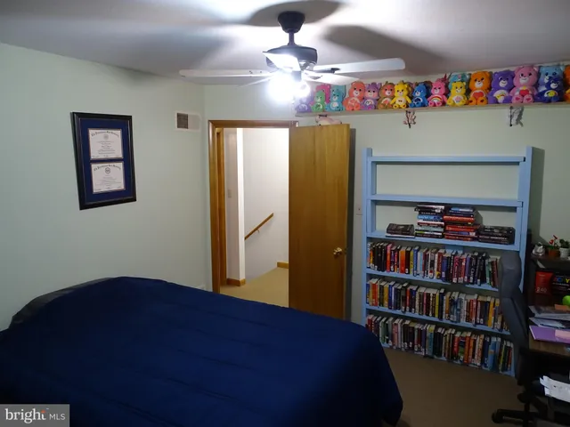 a bedroom with a bed and a book shelf