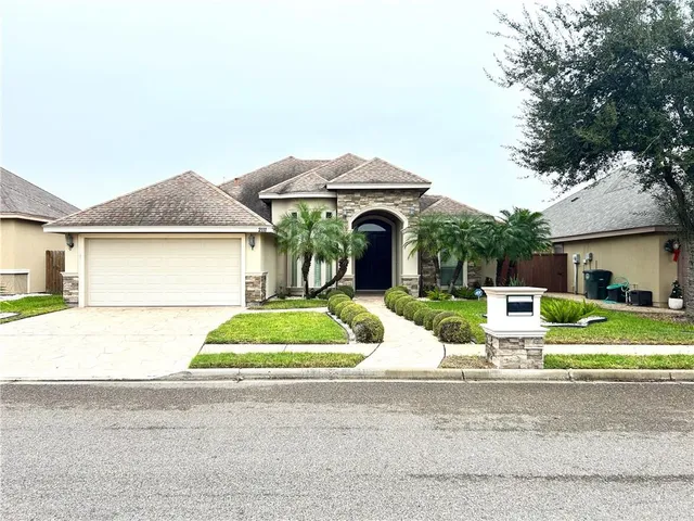 a front view of a house with a yard and garage