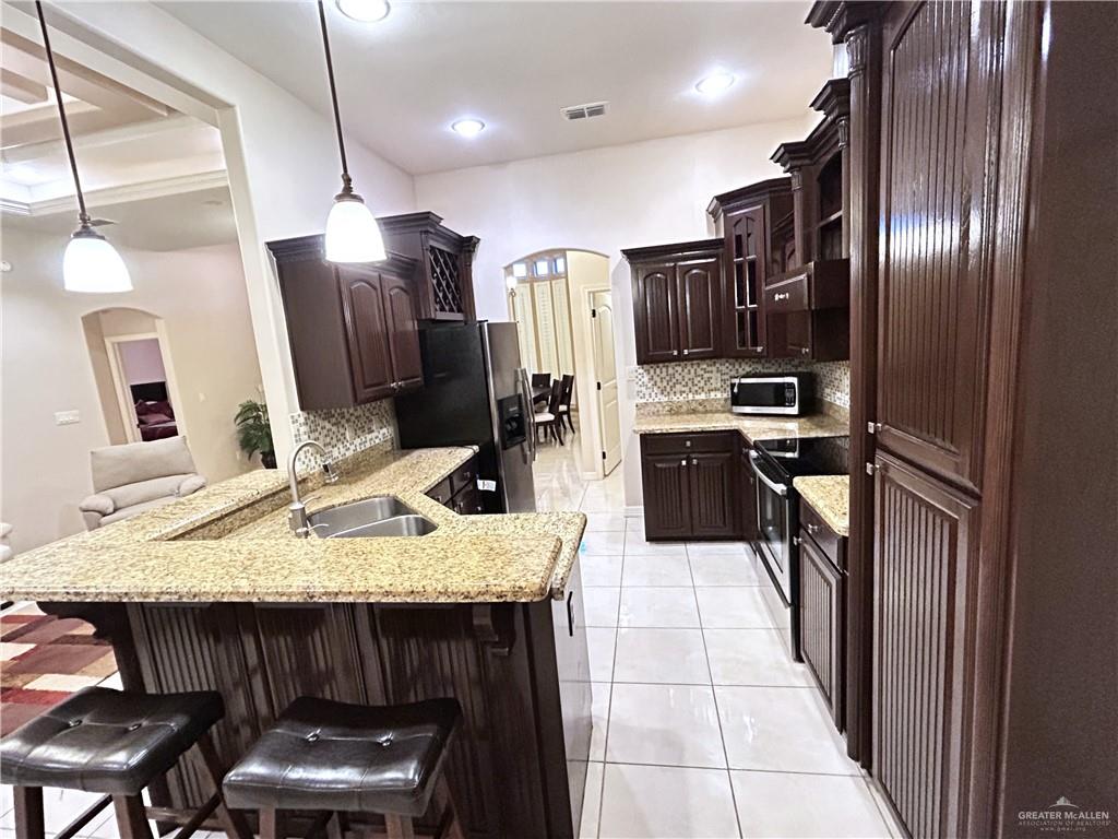 2111 Solar Drive Mission, TX 78574 - Photo 12 of 20 a kitchen with stainless steel appliances granite countertop a sink refrigerator and cabinets