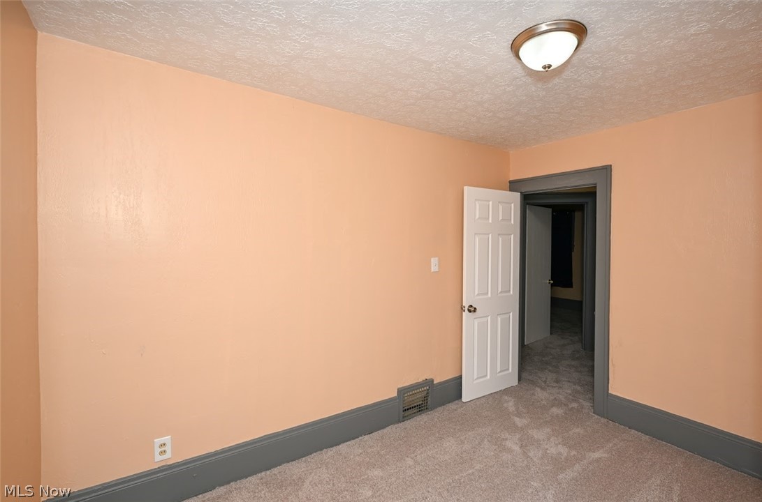 77 West Mildred Avenue Akron, OH 44310 - Photo 20 of 40 Carpeted empty room featuring a textured ceiling and baseboards