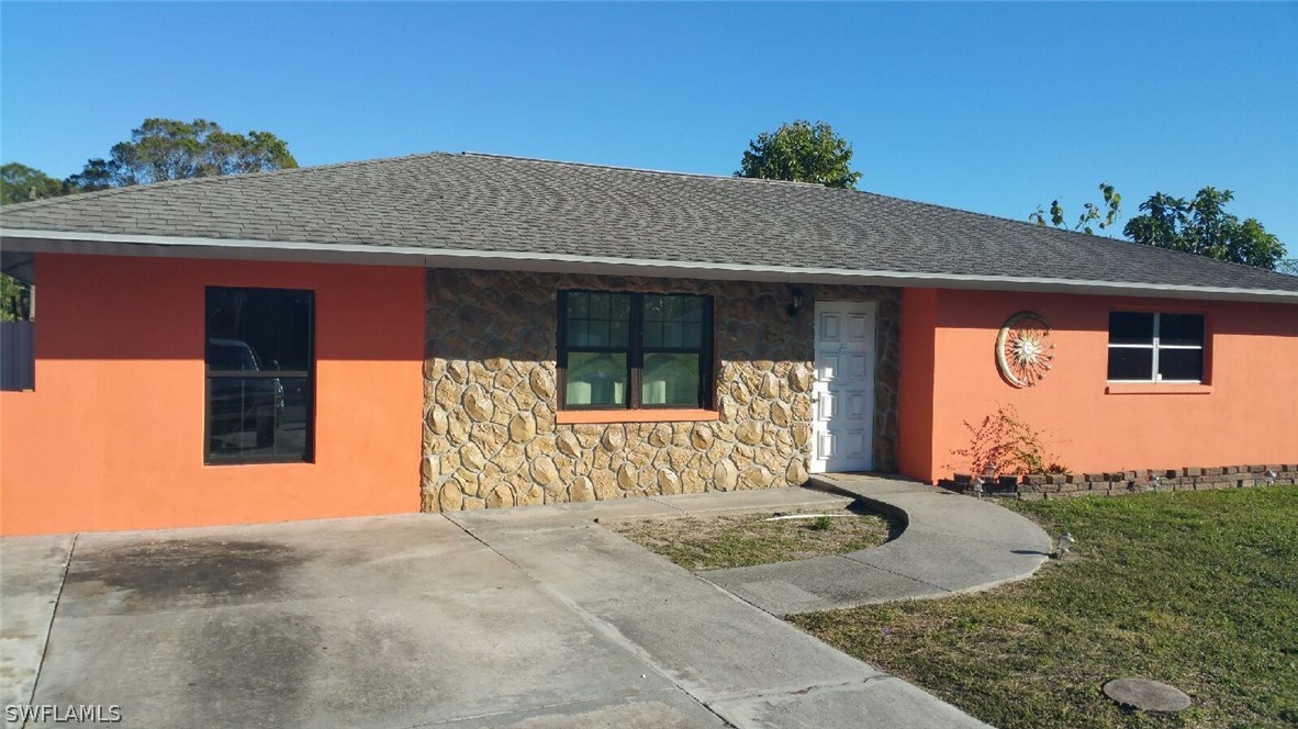 24 Colorado Road Lehigh Acres, FL 33936 - Photo 1 of 12 a front view of a house with garden