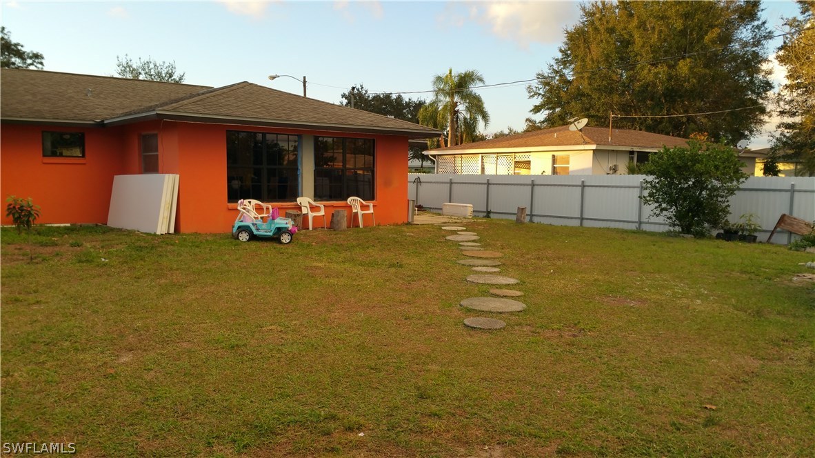 24 Colorado Road Lehigh Acres, FL 33936 - Photo 12 of 12 a front view of house with yard outdoor seating and barbeque oven