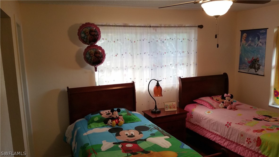 24 Colorado Road Lehigh Acres, FL 33936 - Photo 7 of 12 a bedroom with a bed and ceiling fan