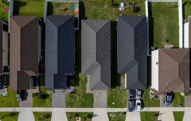 an aerial view of a house with a yard and fountain
