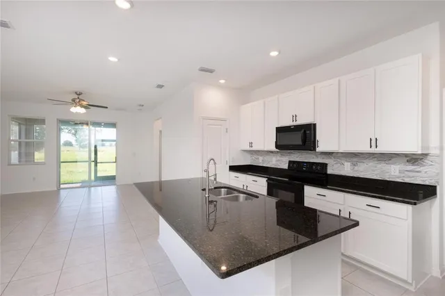 a kitchen with stainless steel appliances granite countertop a sink a stove and microwave