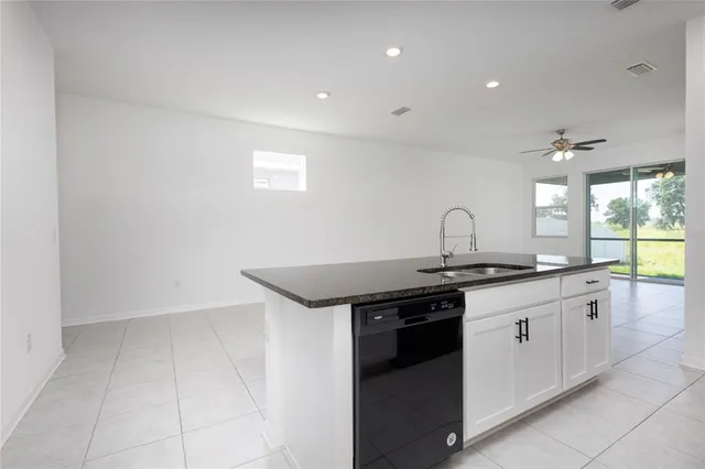 a kitchen with granite countertop a sink and cabinets