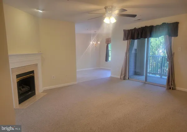 a view of empty room with fan and fireplace