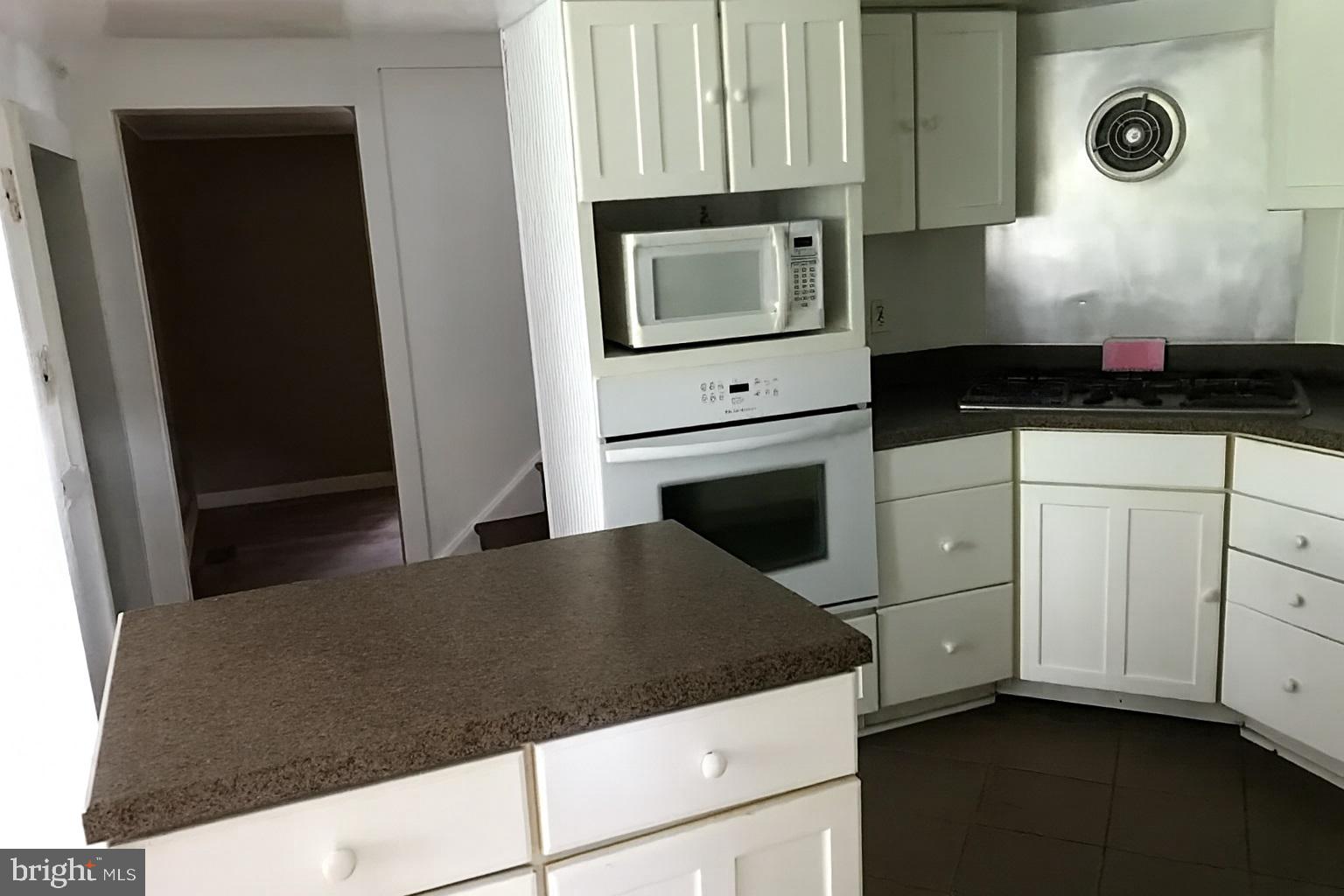 2906 Needmore Road Baker, WV 26801 - Photo 12 of 22 a kitchen with granite countertop white cabinets and black appliances