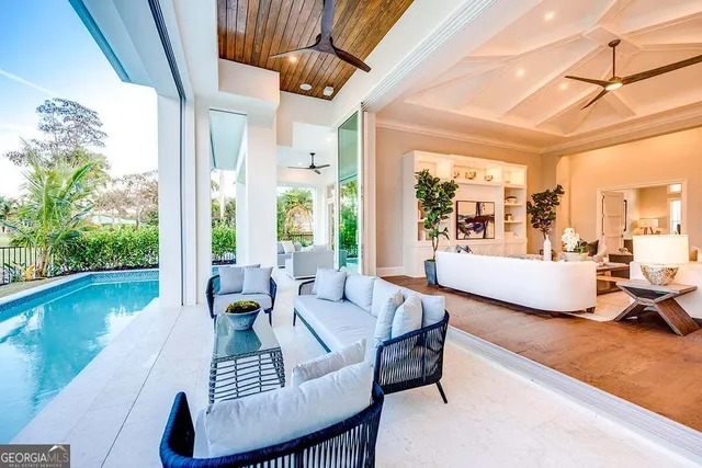 a living room with patio furniture and a large window