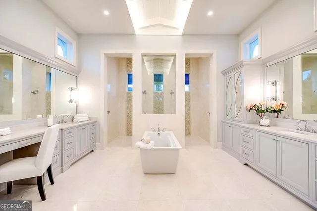 a bathroom with a granite countertop sink a toilet a mirror and bathtub