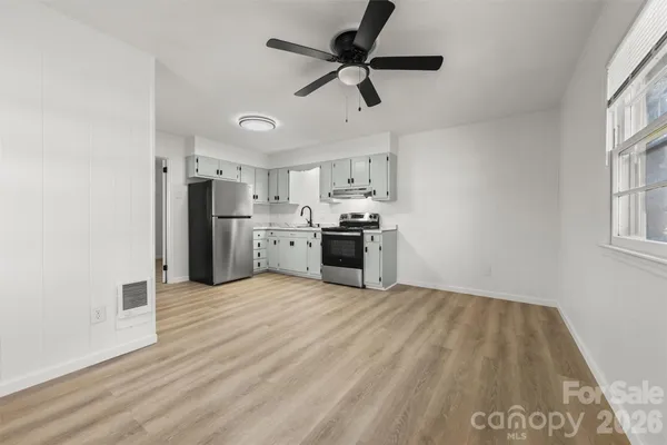 a view of empty room with wooden floor and window