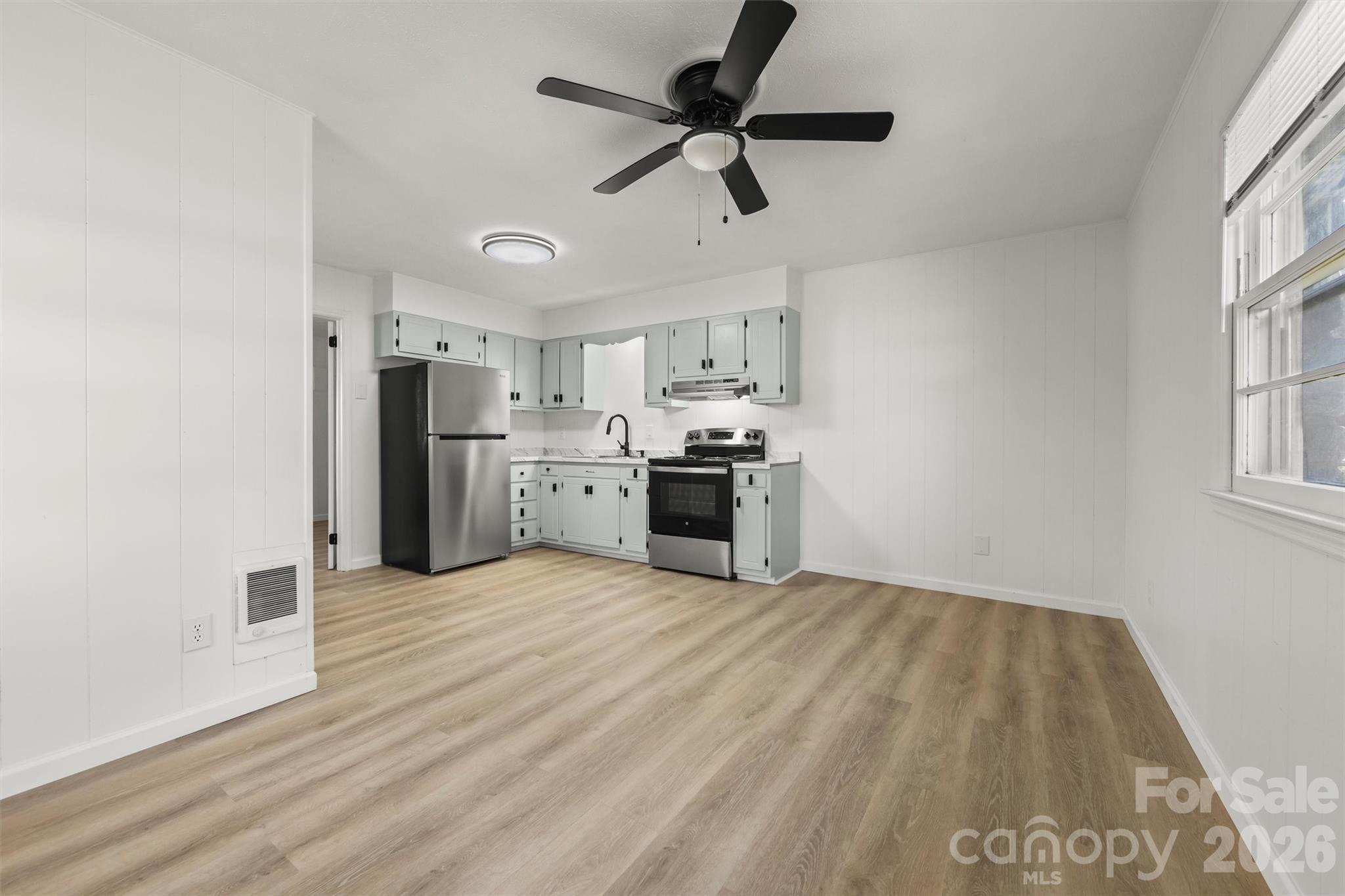 71 Maple Street Clyde, NC 28721 - Photo 4 of 22 a view of kitchen with wooden floor and window