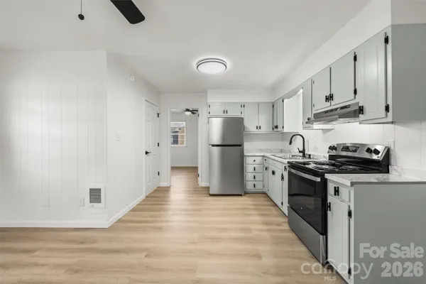 a view of a kitchen with a sink and stainless steel appliances