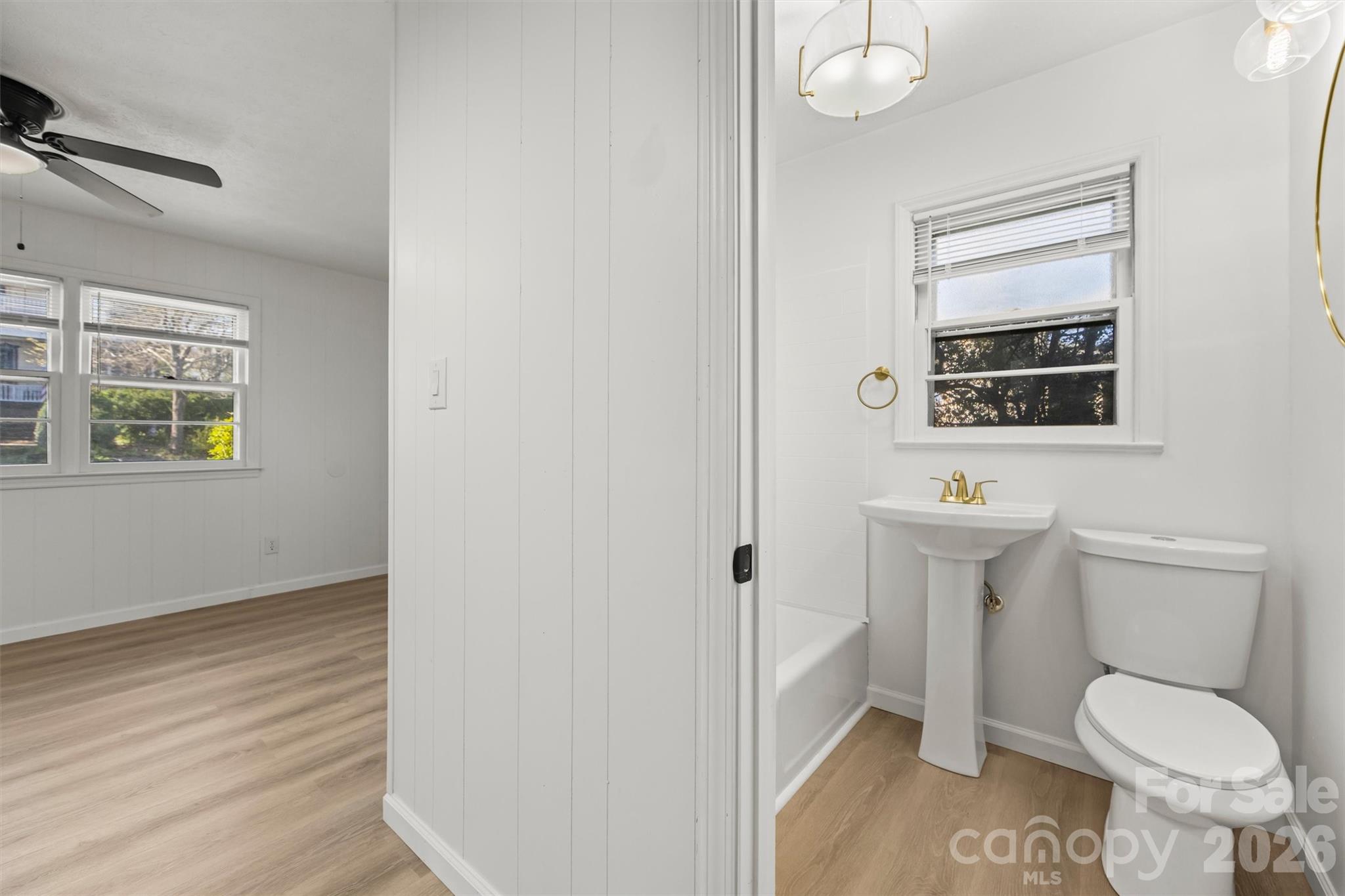 71 Maple Street Clyde, NC 28721 - Photo 9 of 22 a bathroom with a toilet a sink and a window