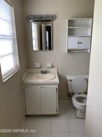 a utility room with a sink a toilet and a window