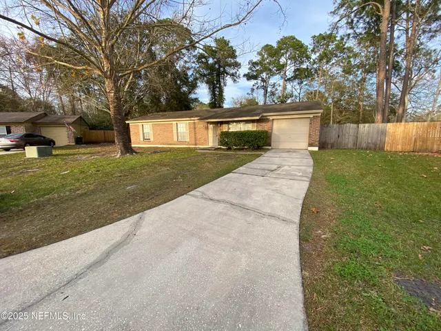 a front view of a house with a yard and a garden