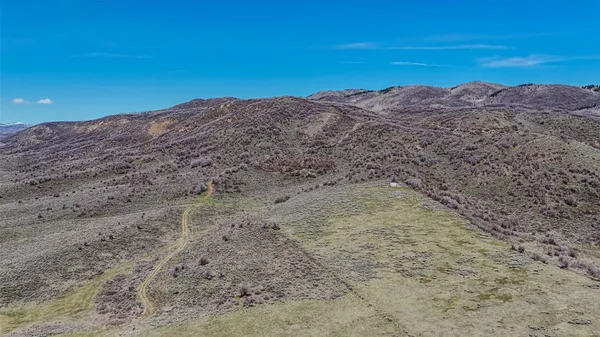 a view of a dry yard with mountains in the background
