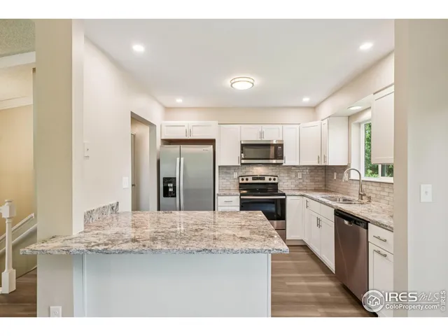 a kitchen with stainless steel appliances kitchen island granite countertop a sink and cabinets