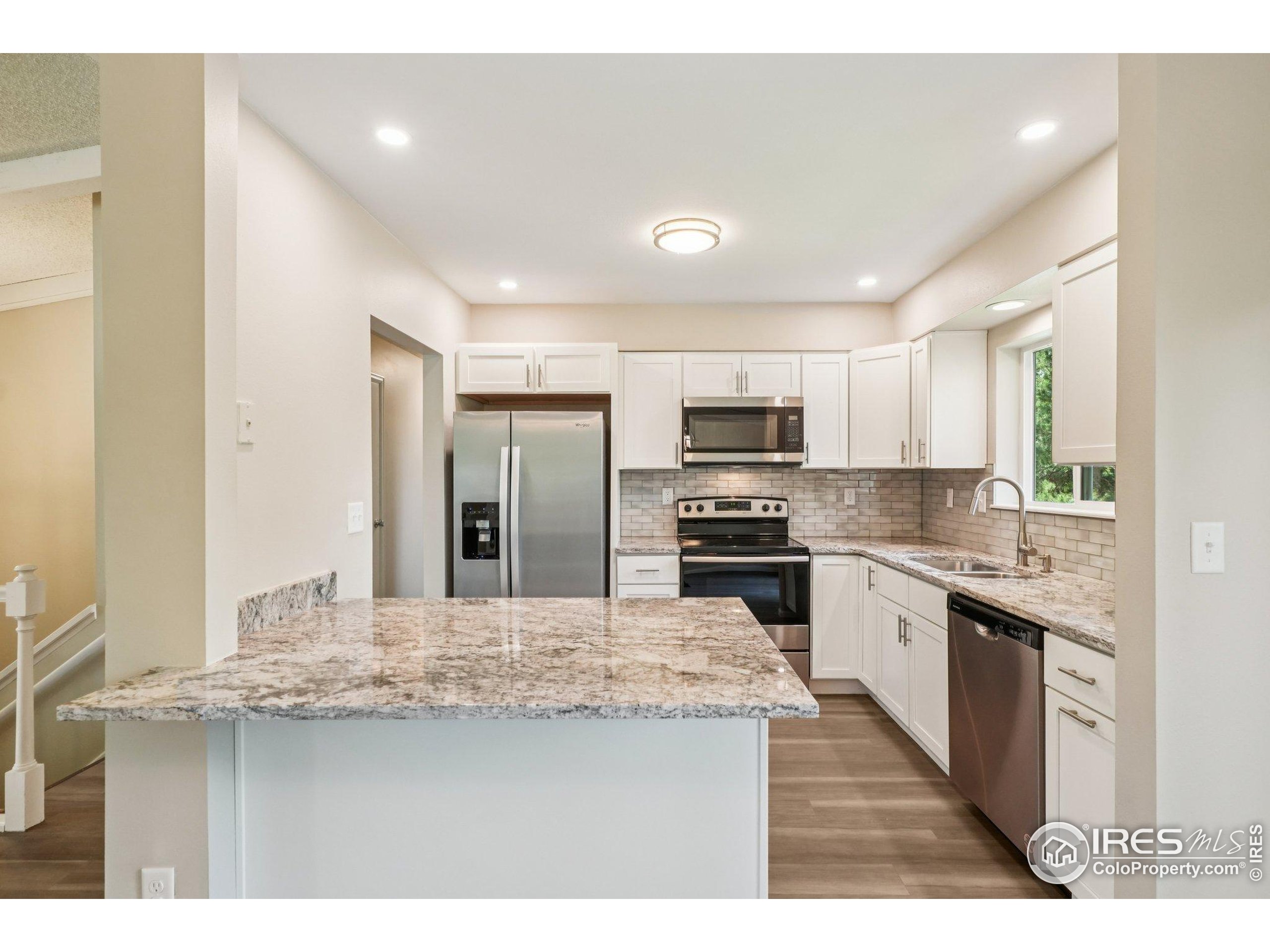 2442 Amherst Street Fort Collins, CO 80525 - Photo 12 of 49 a kitchen with stainless steel appliances kitchen island granite countertop a sink and cabinets