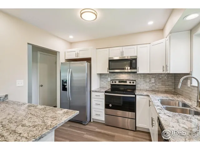 a kitchen with stainless steel appliances granite countertop a stove a refrigerator and a sink