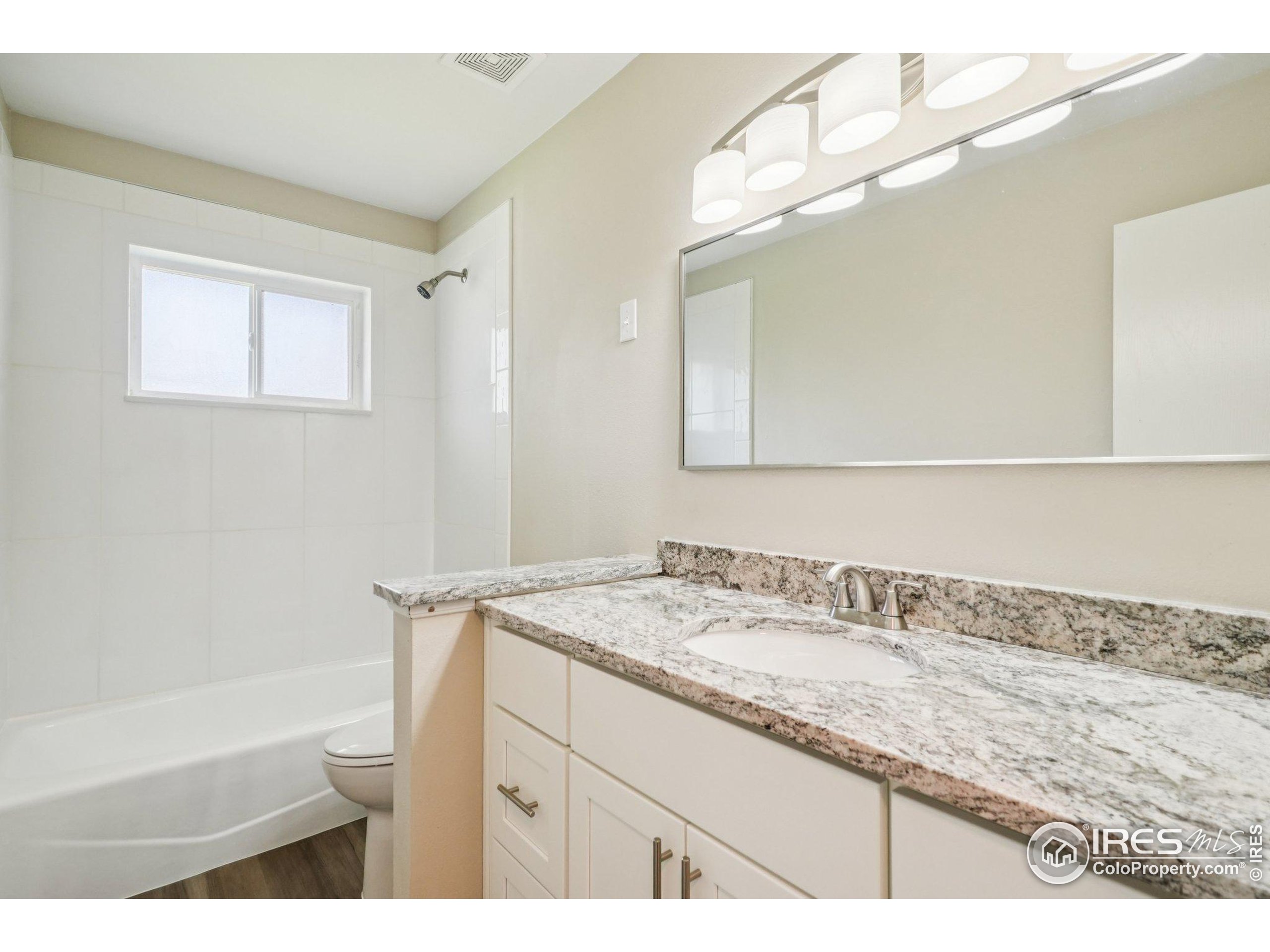 2442 Amherst Street Fort Collins, CO 80525 - Photo 22 of 49 a bathroom with a granite countertop sink a mirror and a bathtub