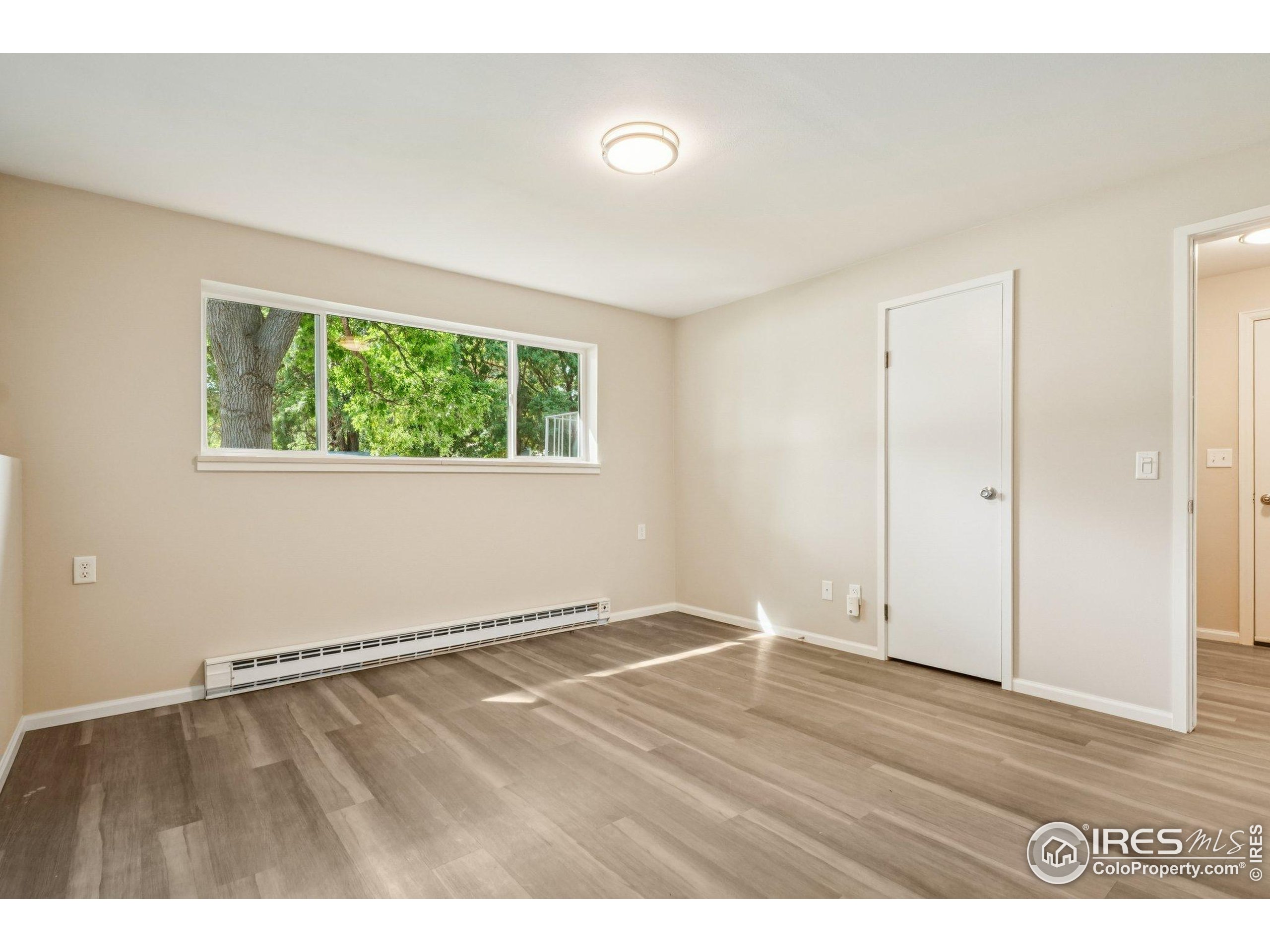 2442 Amherst Street Fort Collins, CO 80525 - Photo 29 of 49 a view of an empty room with wooden floor and a window