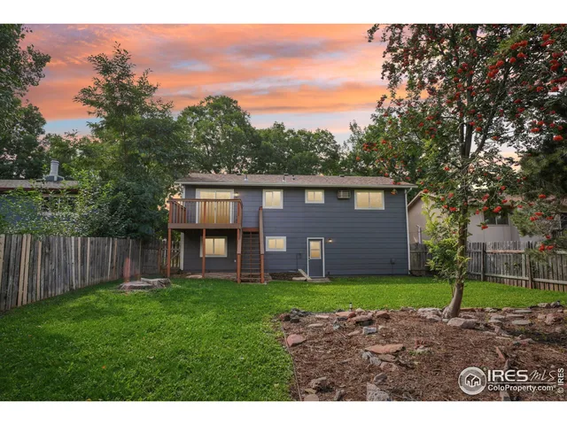 a view of a brick house with a big yard and large trees