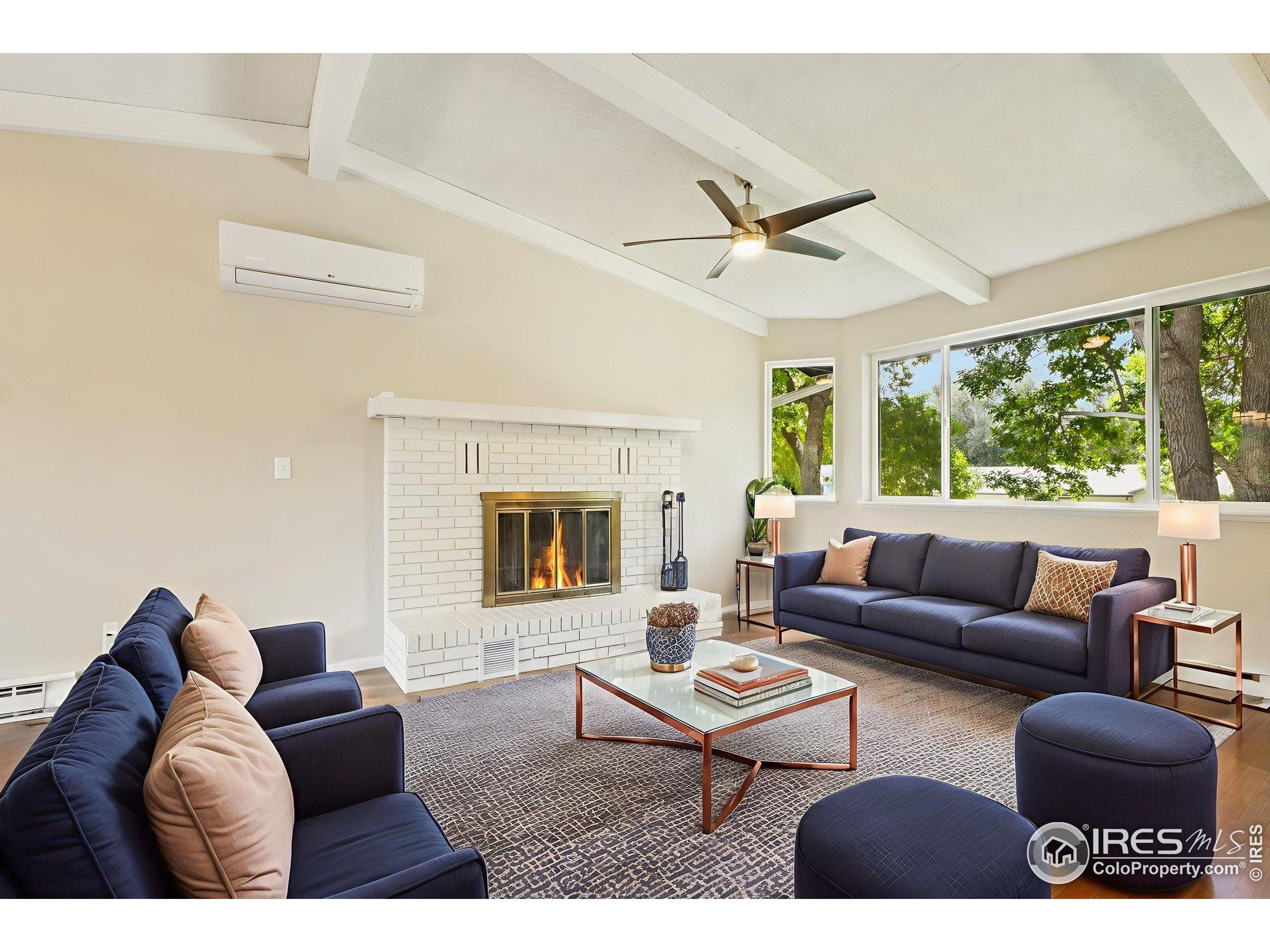 2442 Amherst Street Fort Collins, CO 80525 - Photo 6 of 49 a living room with furniture a ceiling fan and a fireplace