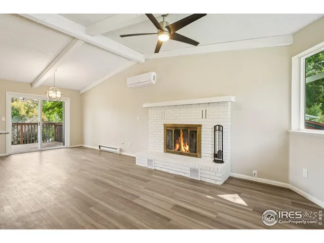 an empty room with windows and fireplace