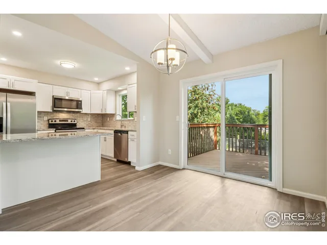 a open kitchen with granite countertop a refrigerator stove top oven and cabinets