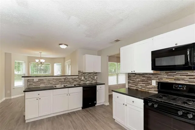 a kitchen with stainless steel appliances kitchen island granite countertop a stove sink and microwave