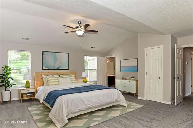 a bedroom with a large bed a flat tv screen and dresser