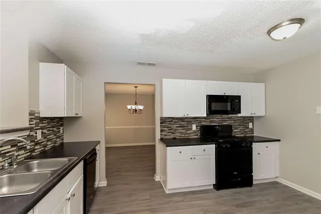 a kitchen with a sink stove and microwave