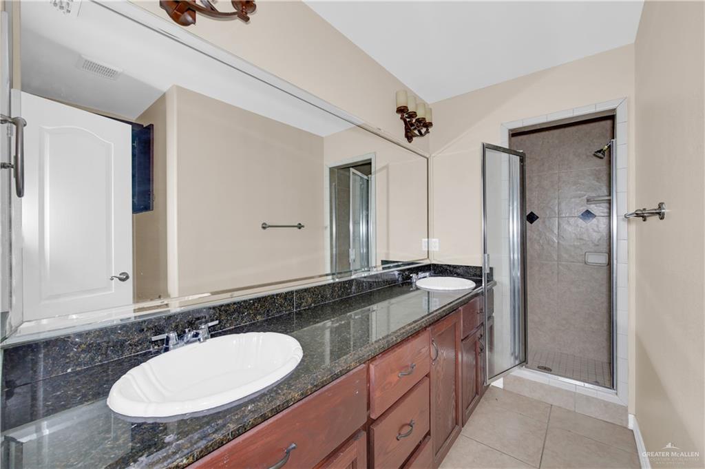 3700 South Embassy Avenue, Unit 3 Pharr, TX 78577 - Photo 8 of 12 a bathroom with a granite countertop sink and a mirror
