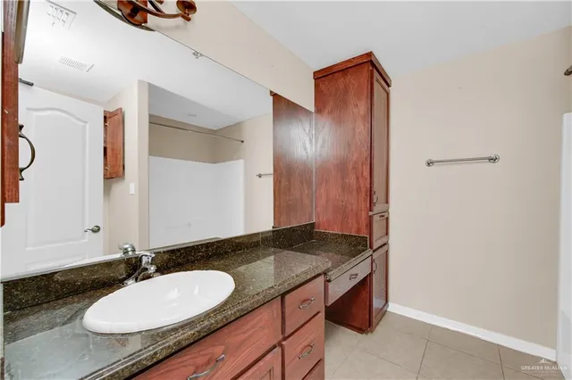 a bathroom with a granite countertop sink and a mirror