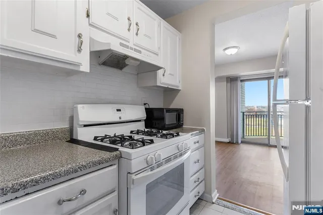 a kitchen with stainless steel appliances granite countertop a sink a stove and a refrigerator