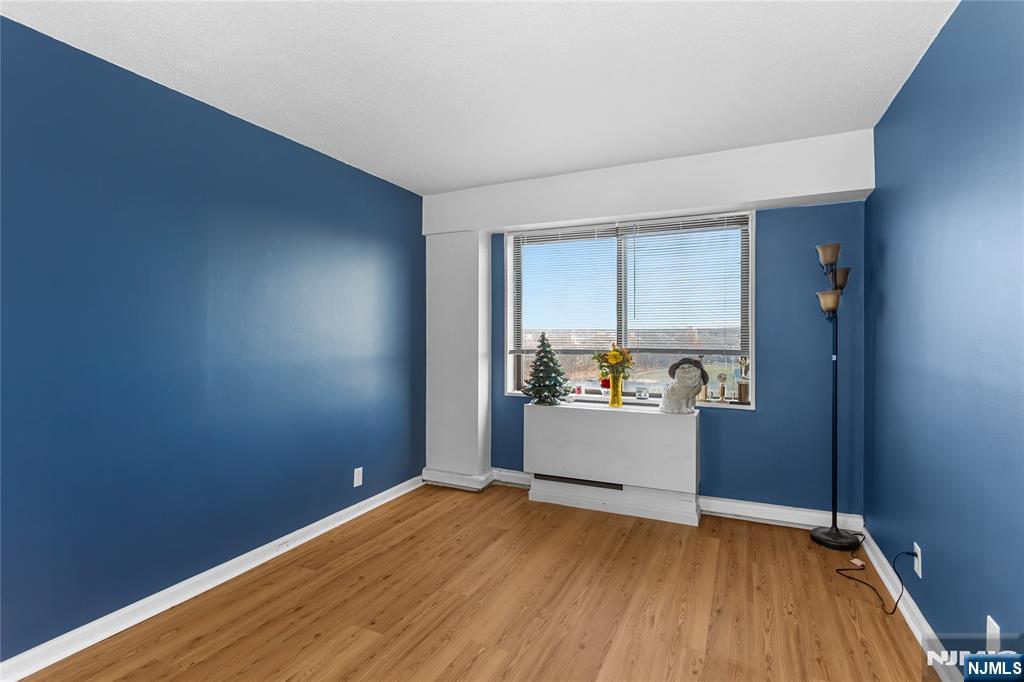 150 Overlook Avenue, Unit 6E Hackensack, NJ 07601 - Photo 14 of 30 an empty room with wooden floor and windows