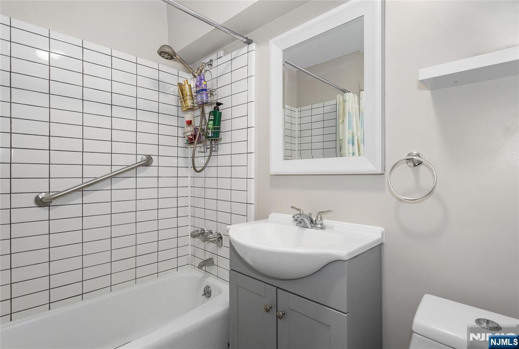 150 Overlook Avenue, Unit 6E Hackensack, NJ 07601 - Photo 16 of 30 a bathroom with a sink a mirror and a shower