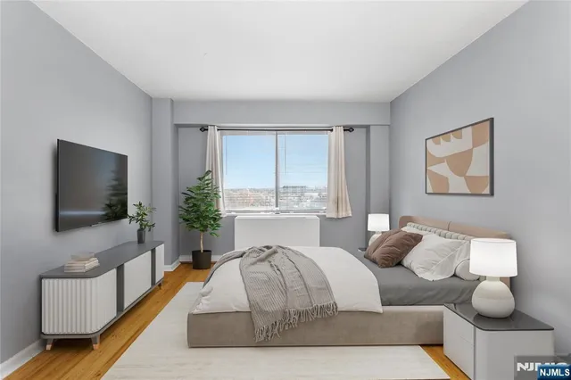 a spacious bedroom with a bed and a flat screen tv