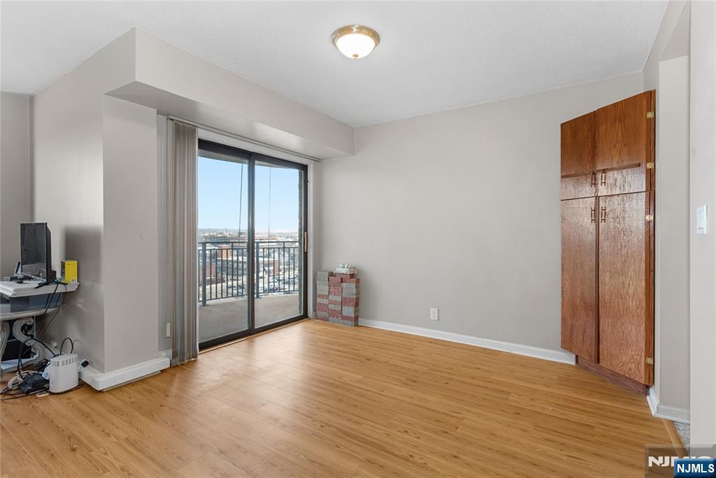 150 Overlook Avenue, Unit 6E Hackensack, NJ 07601 - Photo 9 of 30 a view of an empty room with wooden floor and a window