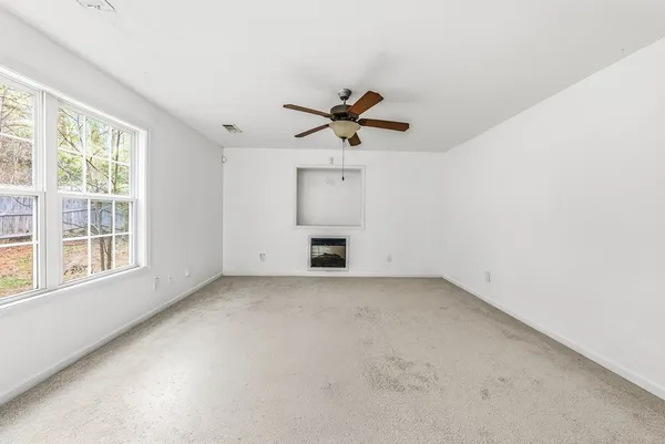 an empty room with a window and a ceiling fan