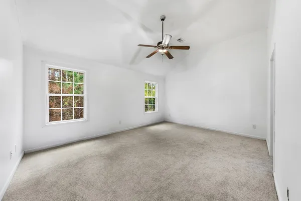 an empty room with a window and a fan