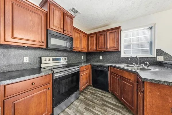 a kitchen with stainless steel appliances granite countertop a sink stove and cabinets