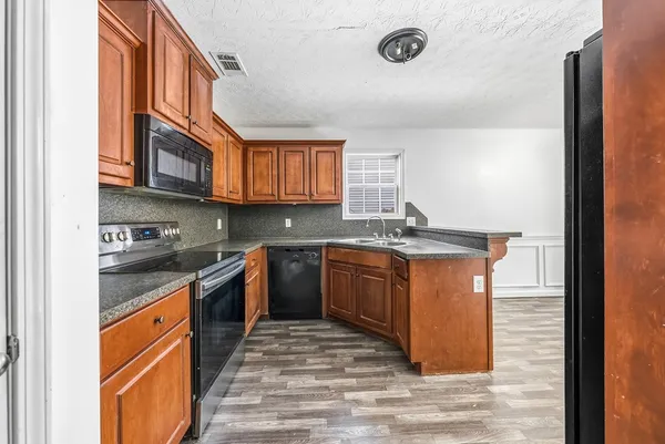 a kitchen with stainless steel appliances granite countertop a stove a sink and a microwave