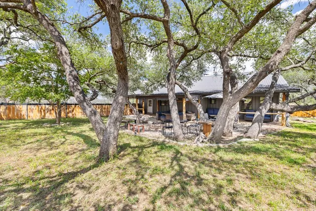 a view of house with backyard and sitting area